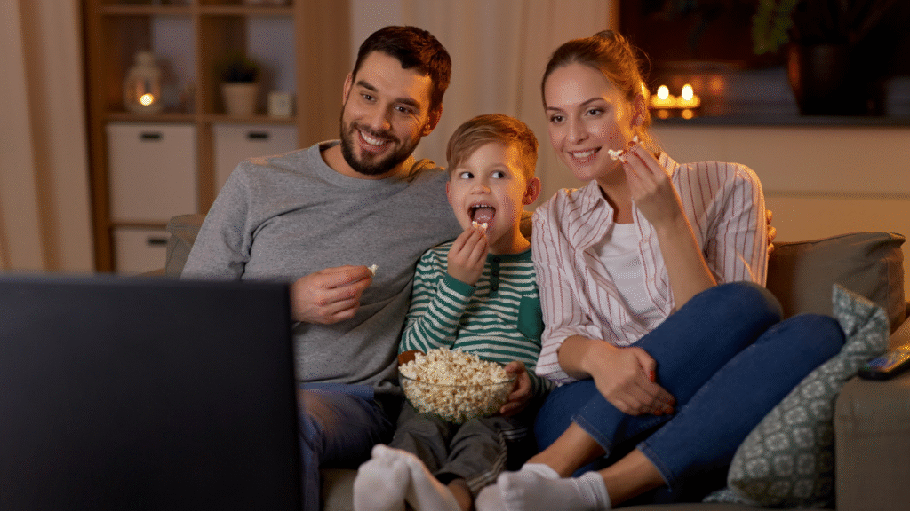 Family watching TV after after applying for government energy rebates through AERA